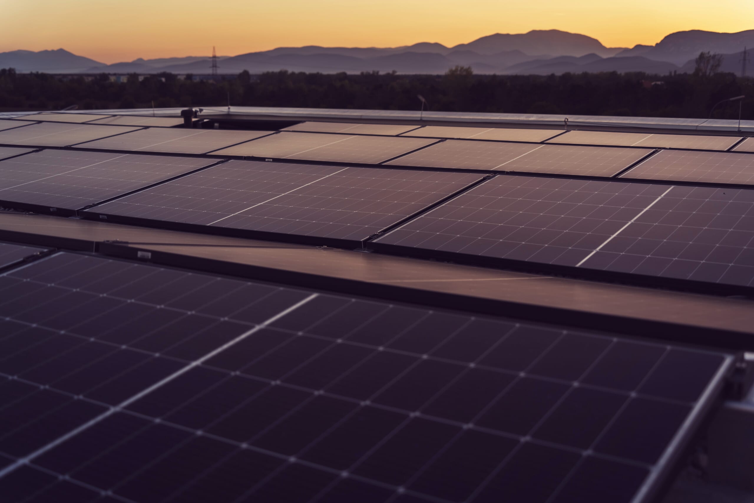 Image of a commercial rooftop solar installation at sunrise