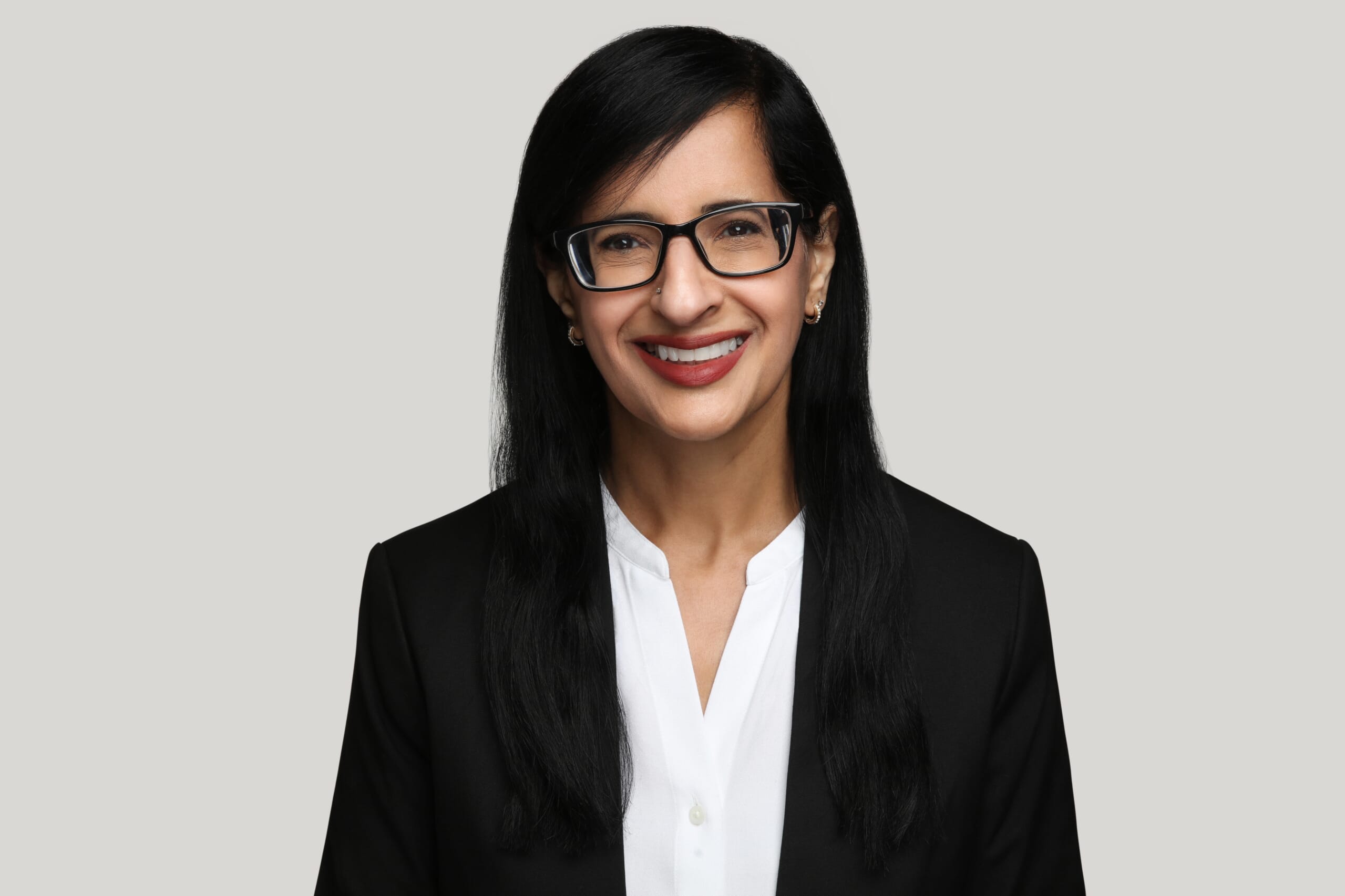 Smiling lady with glasses on grey background