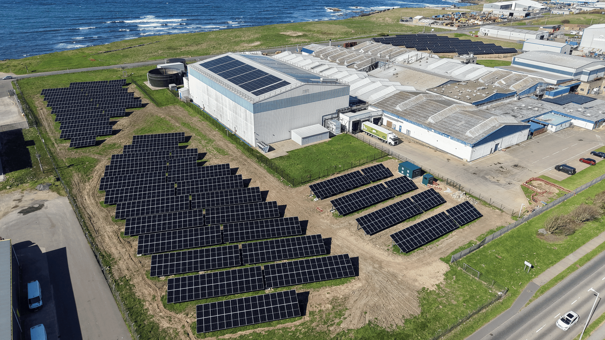 Commercial building adjacent to the coastline showcasing ground mount and roof top solar