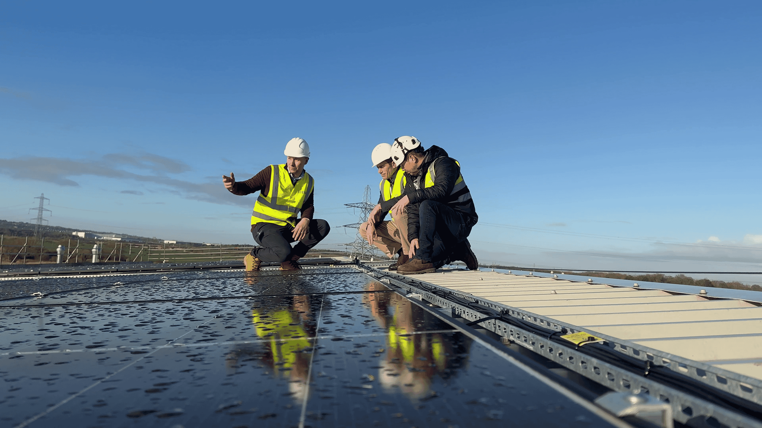 Three workmen on roof inspecting solar